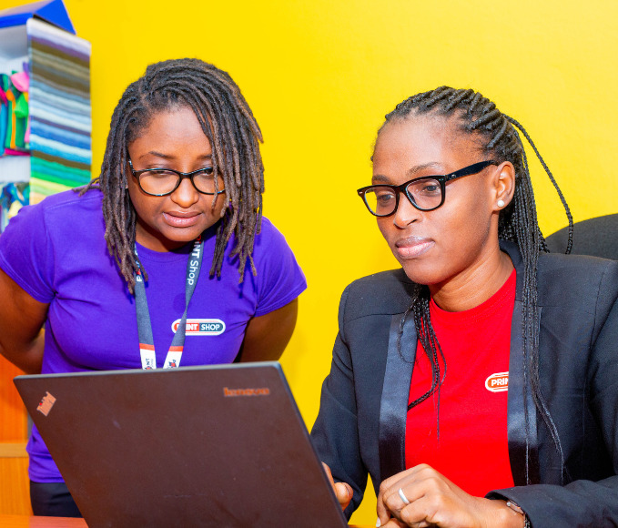 Two women process orders on a laptop.