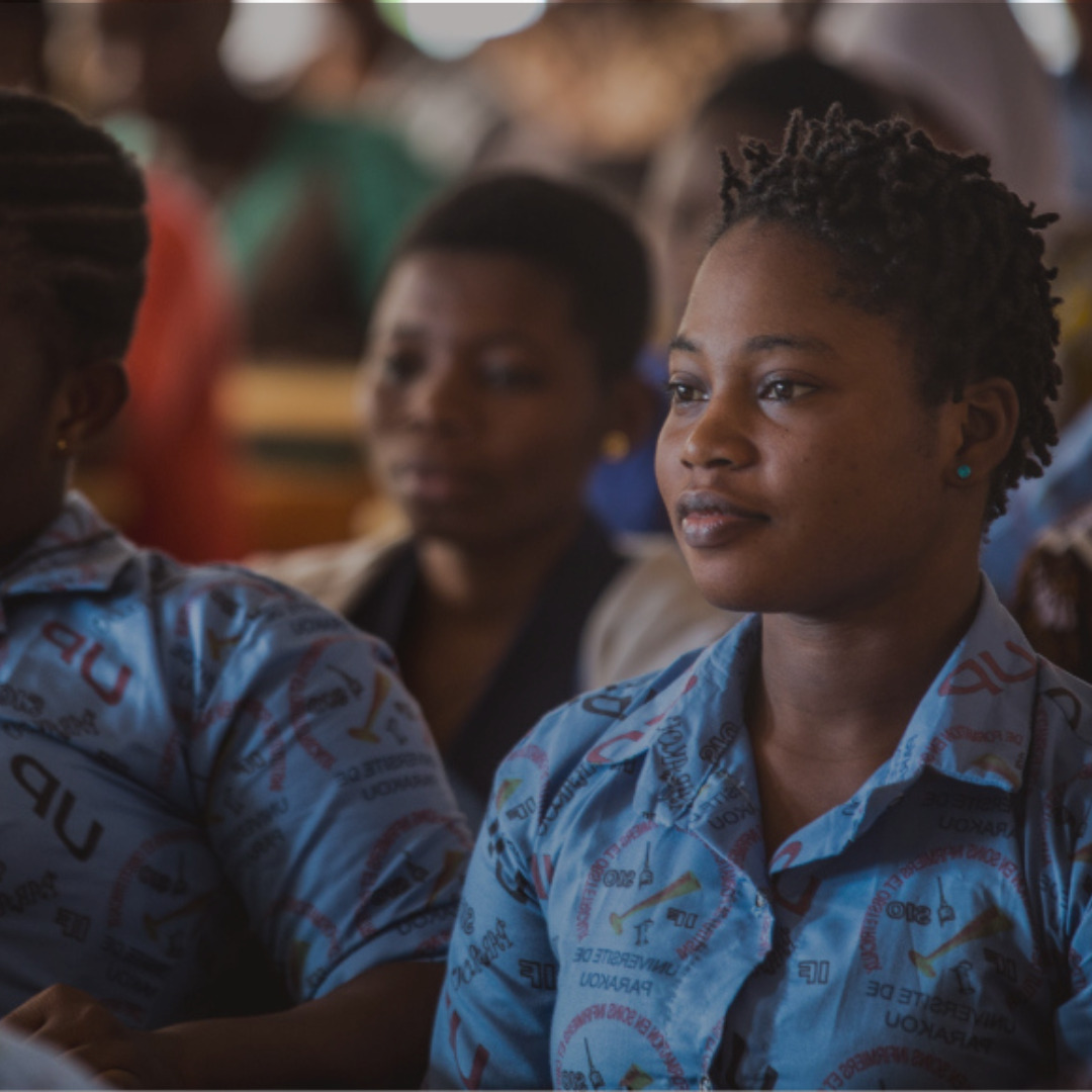 Girl sitting in a classroom with uniform on.